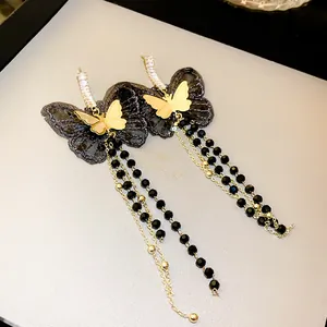 Close-up detail of elegant black lace butterfly earrings with stylish long beaded tassels