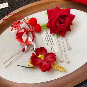 Dettaglio di forcine in stile cinese con rosa rossa, pesce rosso e nappe di perle.