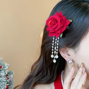 Primo piano di un fermaglio per capelli con rosa rossa e nappe di perle su una modella.