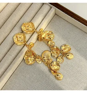 Dettaglio di orecchini a goccia in oro martellato vintage in un vassoio portagioie.