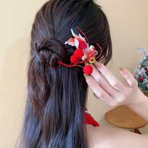 Dettaglio di un fermaglio per capelli con carpa koi rossa in stile cinese su uno chignon