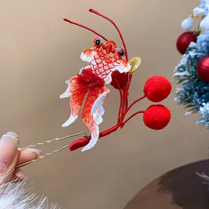Dettaglio di un fermaglio per capelli in stile cinese con pesce rosso ricamato e pompon