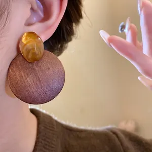 Elegant round wooden earrings with translucent amber resin detail in Maillard style