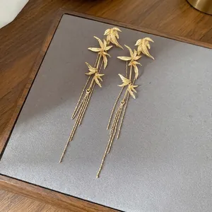 Elegant gold bamboo leaf tassel earrings with silver needles in minimalist Chinese style
