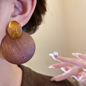 Detailed view of vintage wooden round earrings with amber resin accents