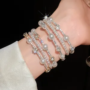 Elegante pulsera multicapa con perlas y brillantes diamantes de imitación en la muñeca