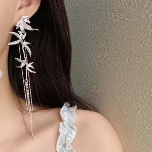 Detail view of elegant silver bamboo leaf tassel earrings with delicate beaded chains