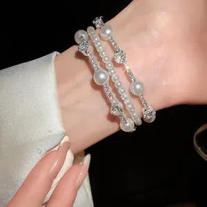 Primer plano de una pulsera multicapa de perlas y pedrería de estilo retro francés