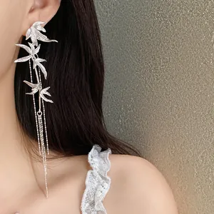 Detailed view of elegant silver bamboo leaf tassel earrings on a model in New Chinese style