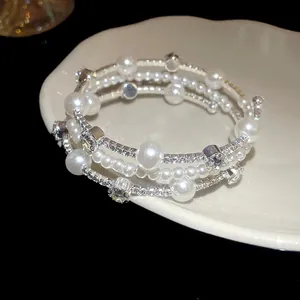 Vista detallada de una elegante pulsera multicapa con perlas sintéticas y cristales