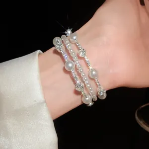 Vista detallada de una elegante pulsera multicapa retro francesa con perlas y strass