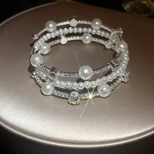 Detalle de una elegante pulsera de varias capas con perlas y diamantes de imitación retro