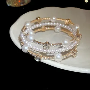 Vista detallada de pulsera multicapa vintage de perlas y diamantes en un plato blanco