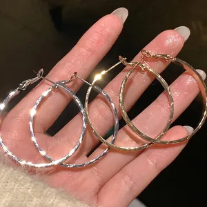 Eleganti orecchini a cerchio testurizzati in oro e argento con raffinato motivo a croce