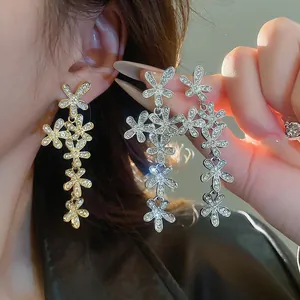 Dettaglio degli eleganti orecchini pendenti a fiore in zircone oro e argento