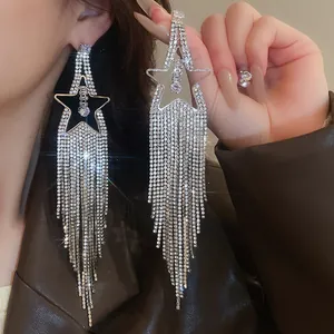 Dettaglio ravvicinato di orecchini a stella in argento con frange di strass