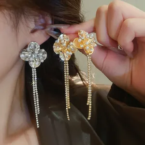 Dettaglio degli orecchini a fiore con nappe in oro e argento con perle e zirconi