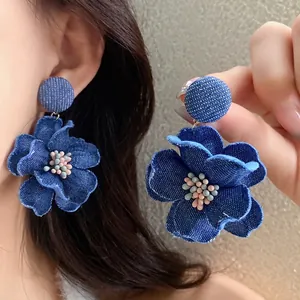 Orecchini a fiore in denim blu con pistillo di perle, accessorio moda.