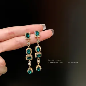 Elegantes pendientes largos geométricos con cristales verdes y acabado dorado