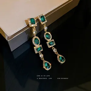 Elegantes pendientes largos geométricos con cristales verde esmeralda y baño de oro