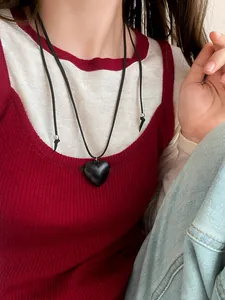 Close-up of a stylish black resin heart pendant necklace featuring an adjustable cord