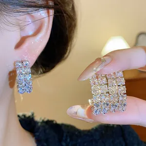 Close-up detail showing sparkling double-row zircon earrings with silver needles for women
