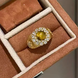 Close-up detail of vintage tiger eye sunflower ring with elegant matte gold finish and clear gems