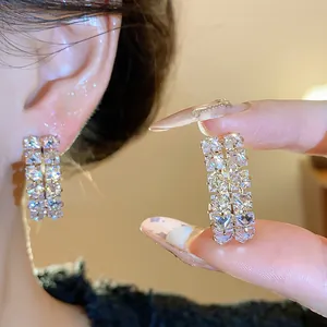 Close-up of elegant zircon double-row oval hoop earrings with brilliant sparkle.