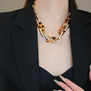 Primo piano di collana girocollo retrò con maglie tartarugate e dorate su modella
