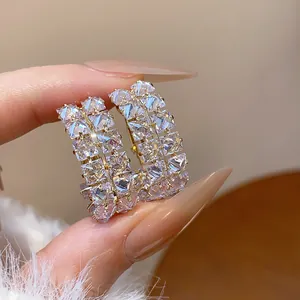 Close-up of elegant gold hoop earrings with double-row sparkling cubic zirconia stones