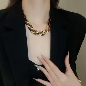 Detailed view of a vintage leopard print chunky chain necklace on a model's neck.