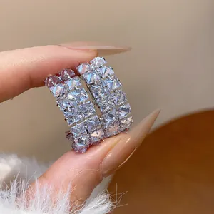 Close-up of double-row zircon oval hoop earrings showing brilliant sparkle and detail.