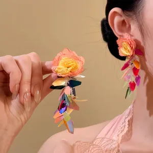 Detailansicht der Raffia-Blumenohrringe mit bunten Acrylquasten im Resort-Stil