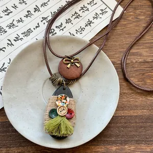 Close-up of bohemian wax rope necklace with tassel and vintage buttons