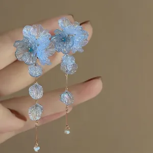 Detailed view of blue translucent flower petal earrings with elegant long tassels