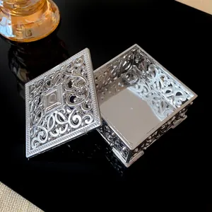 Macro detail of a vintage silver hollow-out metal jewelry box with intricate palace patterns