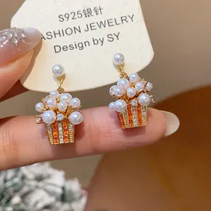 Detailed close-up of 18K gold-plated popcorn earrings with pearls and zircon accents