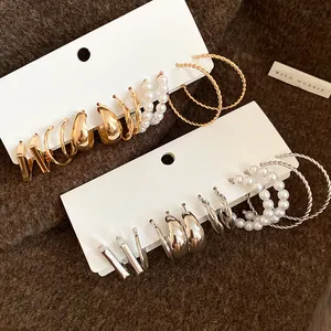 Close-up of vintage pearl and twisted gold silver hoop earring set on white cards