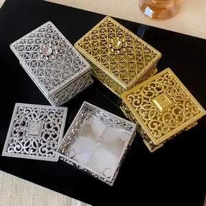 Detailed macro view of hollow metal palace style jewelry storage boxes in gold and silver