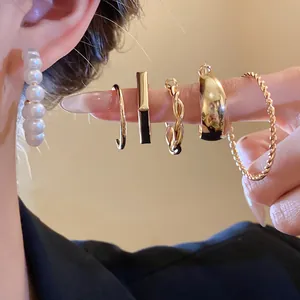 Detail of vintage gold earring set with pearls and twisted designs on model ear