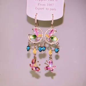 Close-up of colorful butterfly tassel earrings with heart-shaped gems