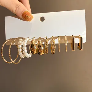 High-quality detail of a mixed gold and pearl earring set displayed on a white card