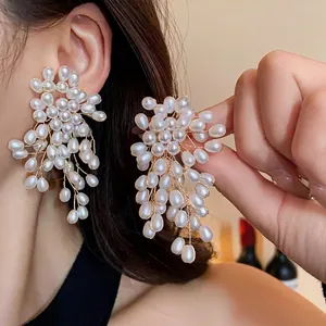 Vintage luxury pearl flower fringe earrings with gold-tone wire details shown on model.