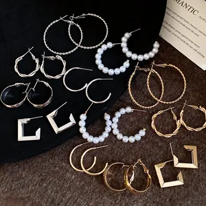 Detailed macro view of a vintage style gold and silver hoop earring set with pearls
