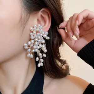 Elegant vintage pearl flower tassel earrings worn on ear in a stylish close-up view