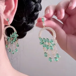 Close-up view of elegant emerald green flower earrings with delicate waterdrop tassels