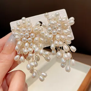 Detailed macro view of elegant pearl tassel flower earrings with gold finish wires.