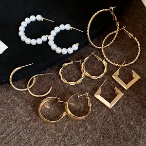 Detailed layout of six pairs of elegant gold-toned pearl and geometric hoop earrings