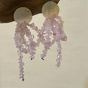 Detail of long tassel earrings with pink irregular stone chips and shell studs