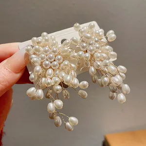Close-up of elegant floral pearl tassel earrings with intricate gold wire detailing